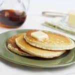 Drie stuks roomkaas pannenkoeken met klontje boter en siroop.