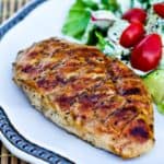 Portie gekruide kipfilet gegrild op de barbecue.