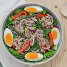 Salade niçoise met ei, tonijn, rode ui en paprika.