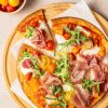 Pizza met mozzarella, cherrytomaten en prosciutto