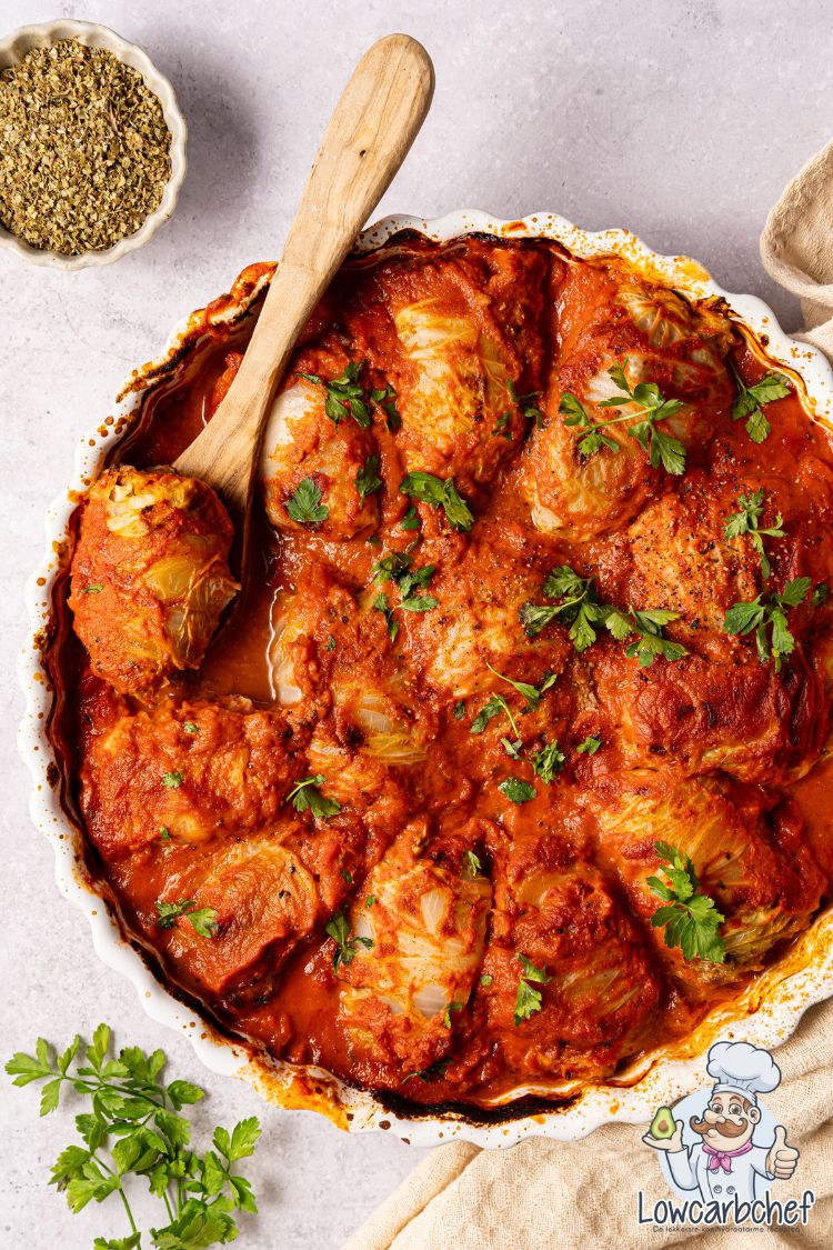 Koolrolletjes gevuld met gehakt en groente in een ovenschaal.